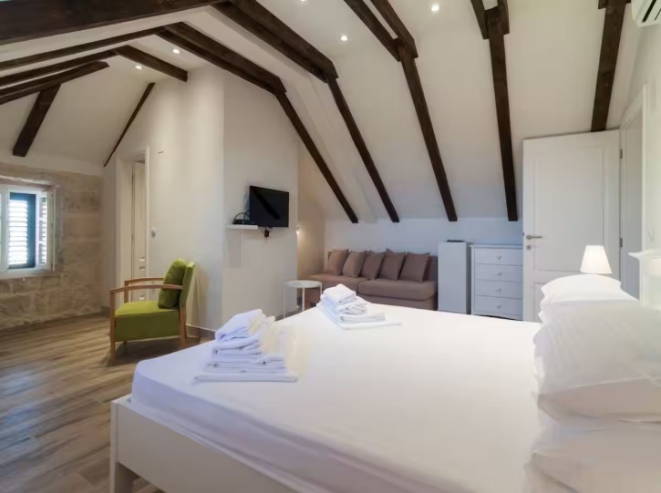Croatian villa bedroom with beamed ceiling