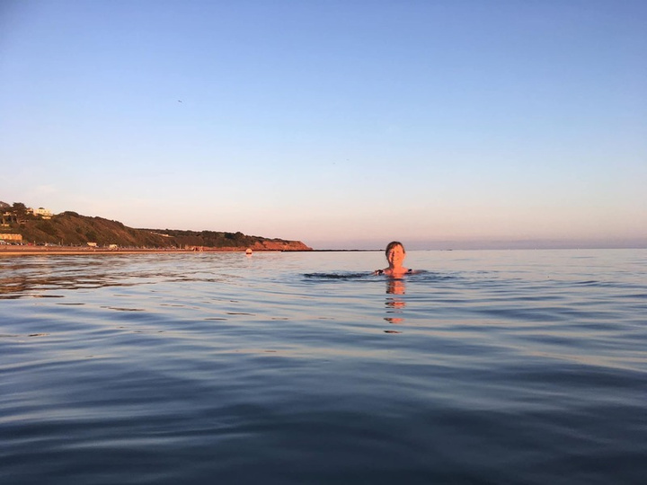 Wild swimmer at sunrise, calm open water